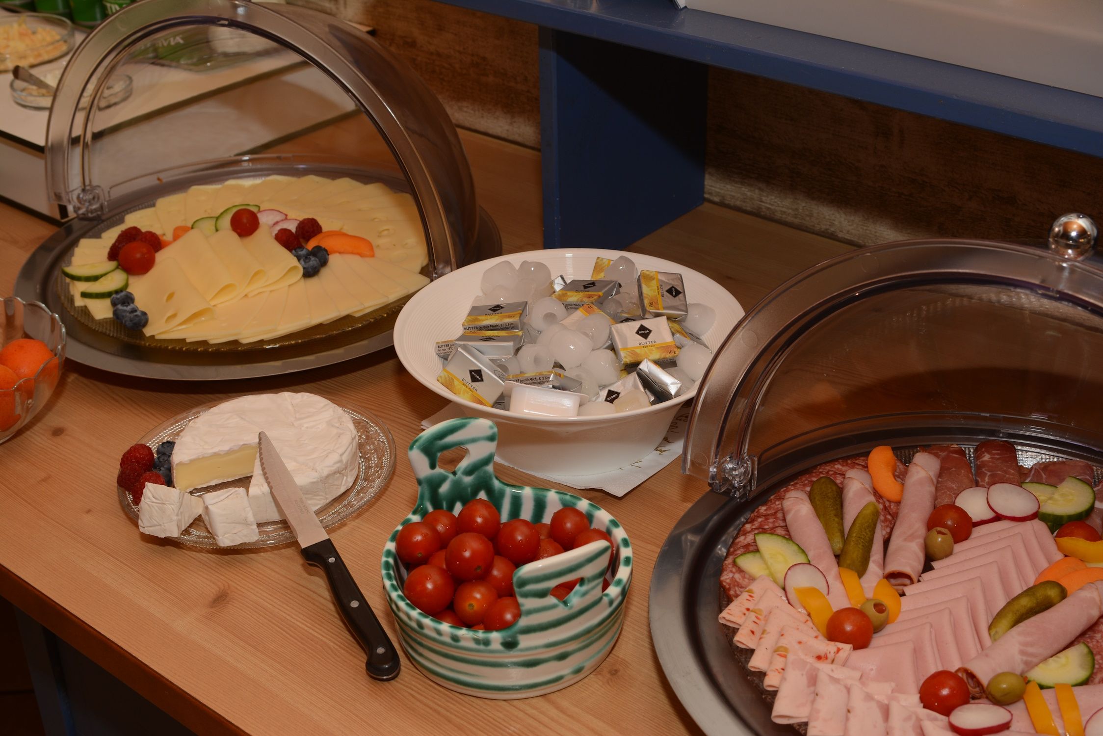 Snídaňový bufet se sýrem, salámem, rajčaty, máslem a hermelínem.