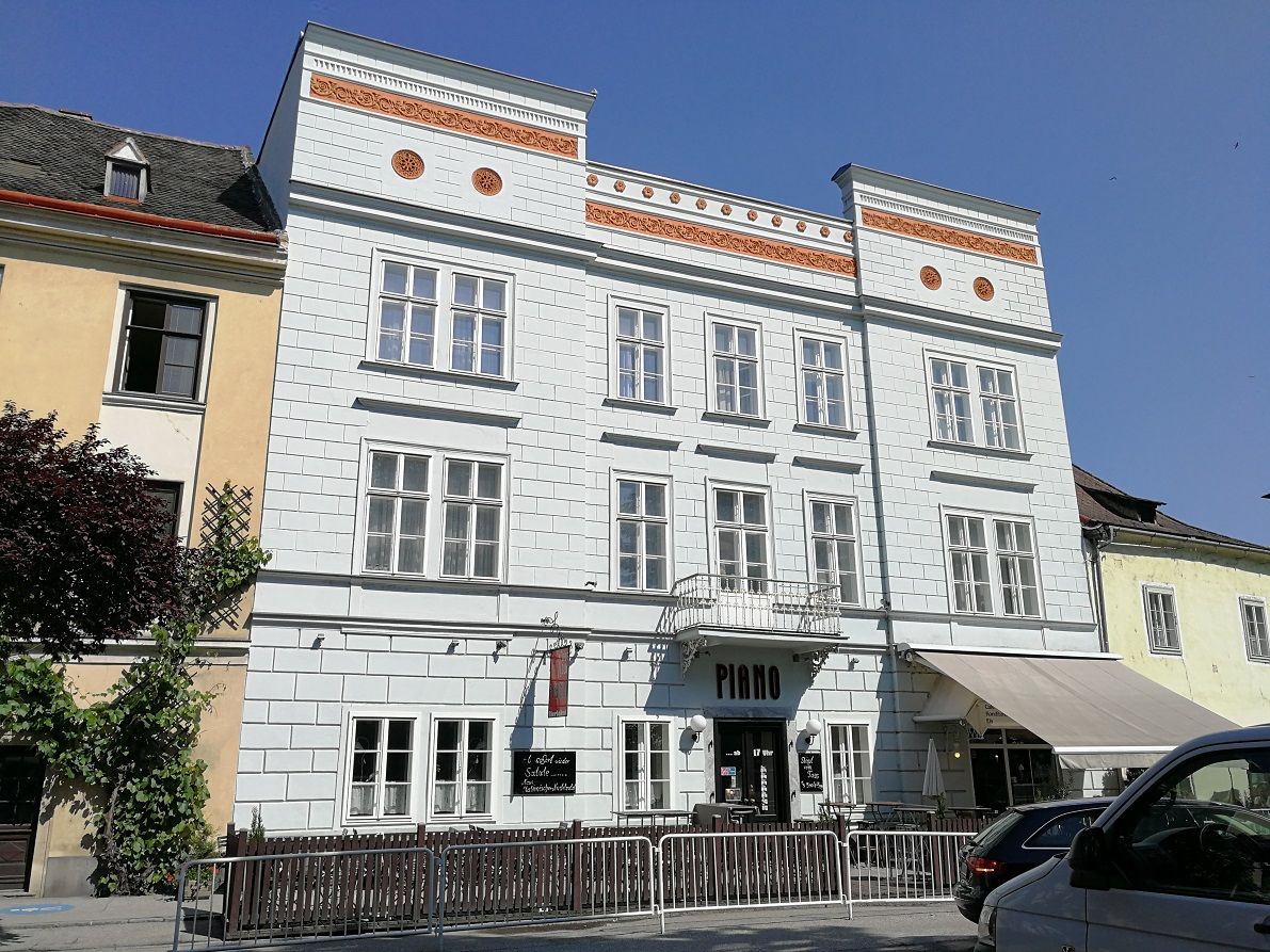 Pohled zvenčí na historickou budovu s označením "Piano" v Kremži.