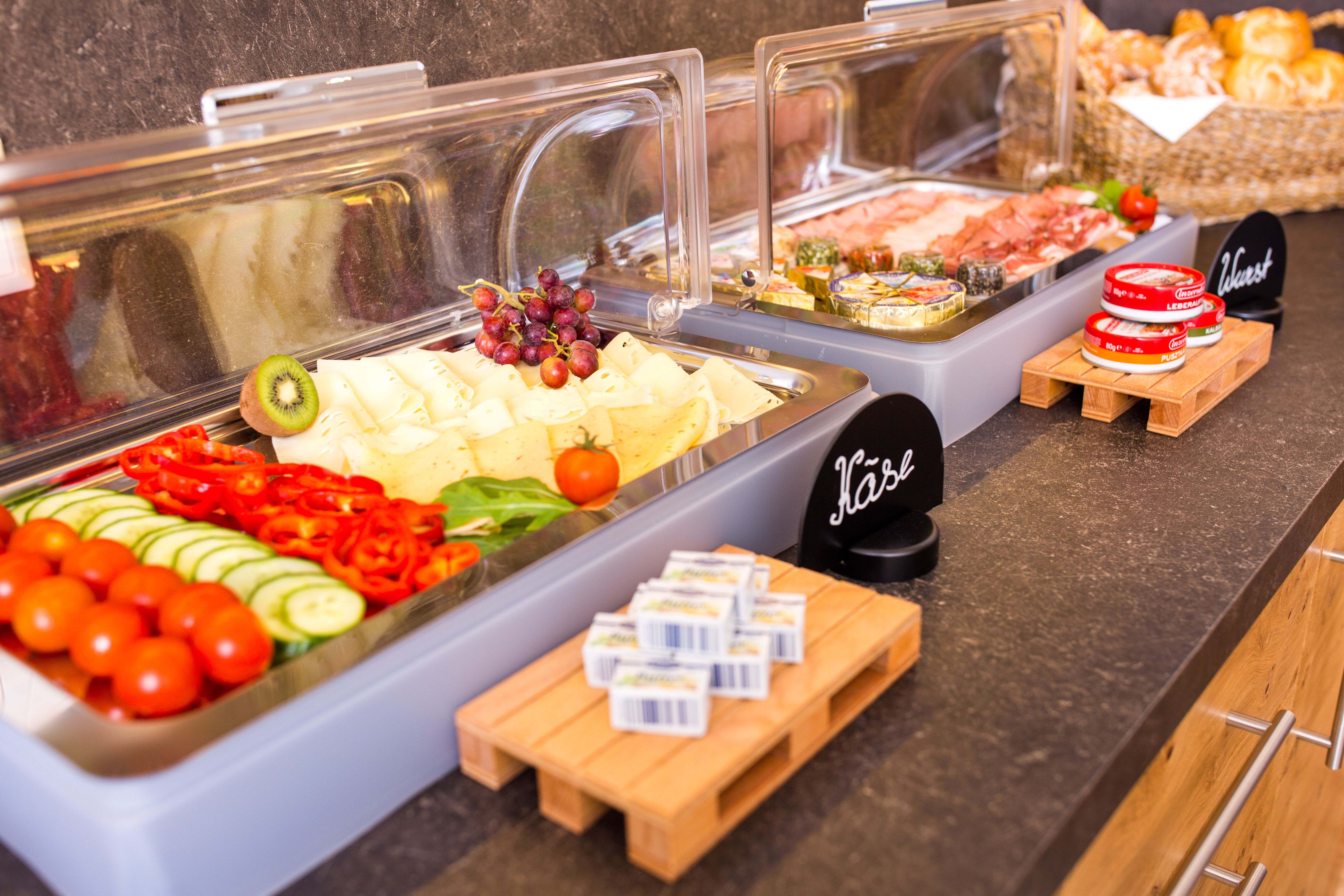 Bufet se sýrem, uzeninami, zeleninou a chlebem.