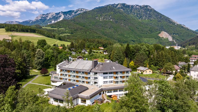 Letecký pohled na velký hotel v zelené hornaté krajině.