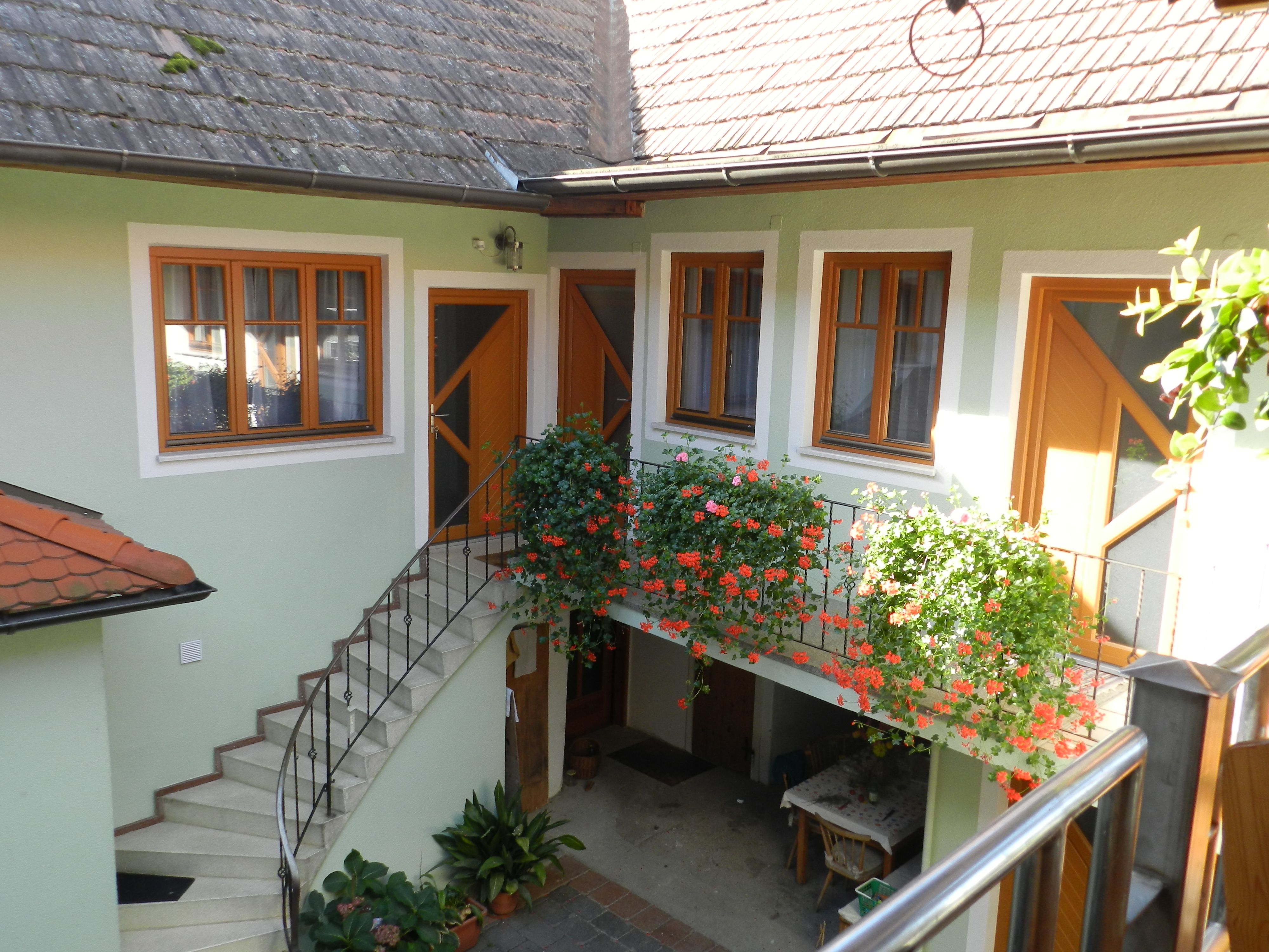 Vnitřní dvůr se schody, květinami a stolem.