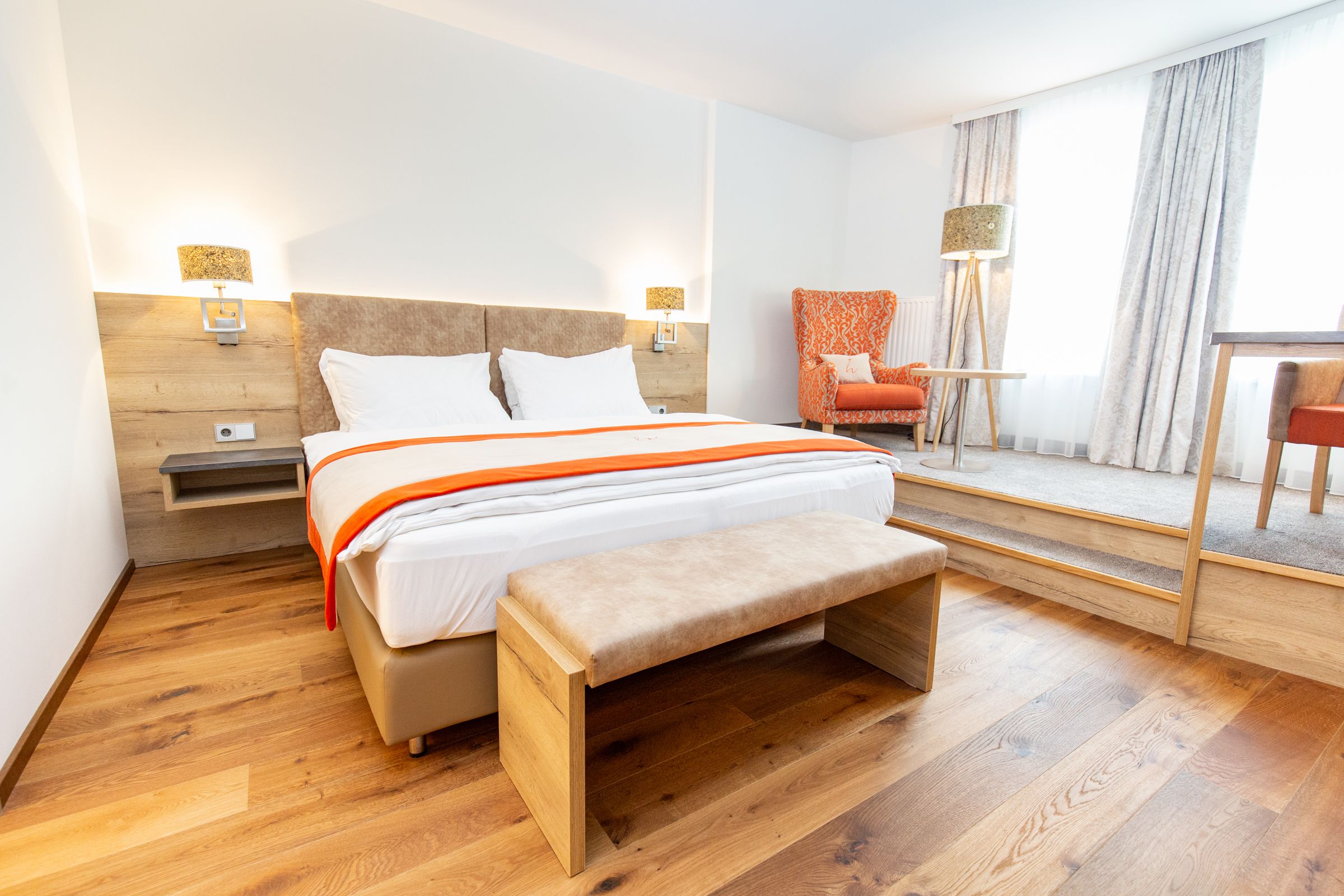 Ein Modernes Doppelzimmer mit einer extra Lese- und Schreibtischecke.