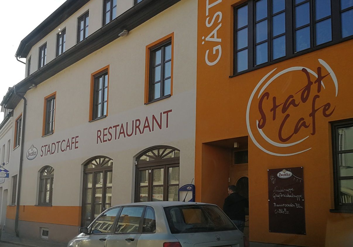 Pohled zvenčí na budovu s označením "Stadtcafe Restaurant".