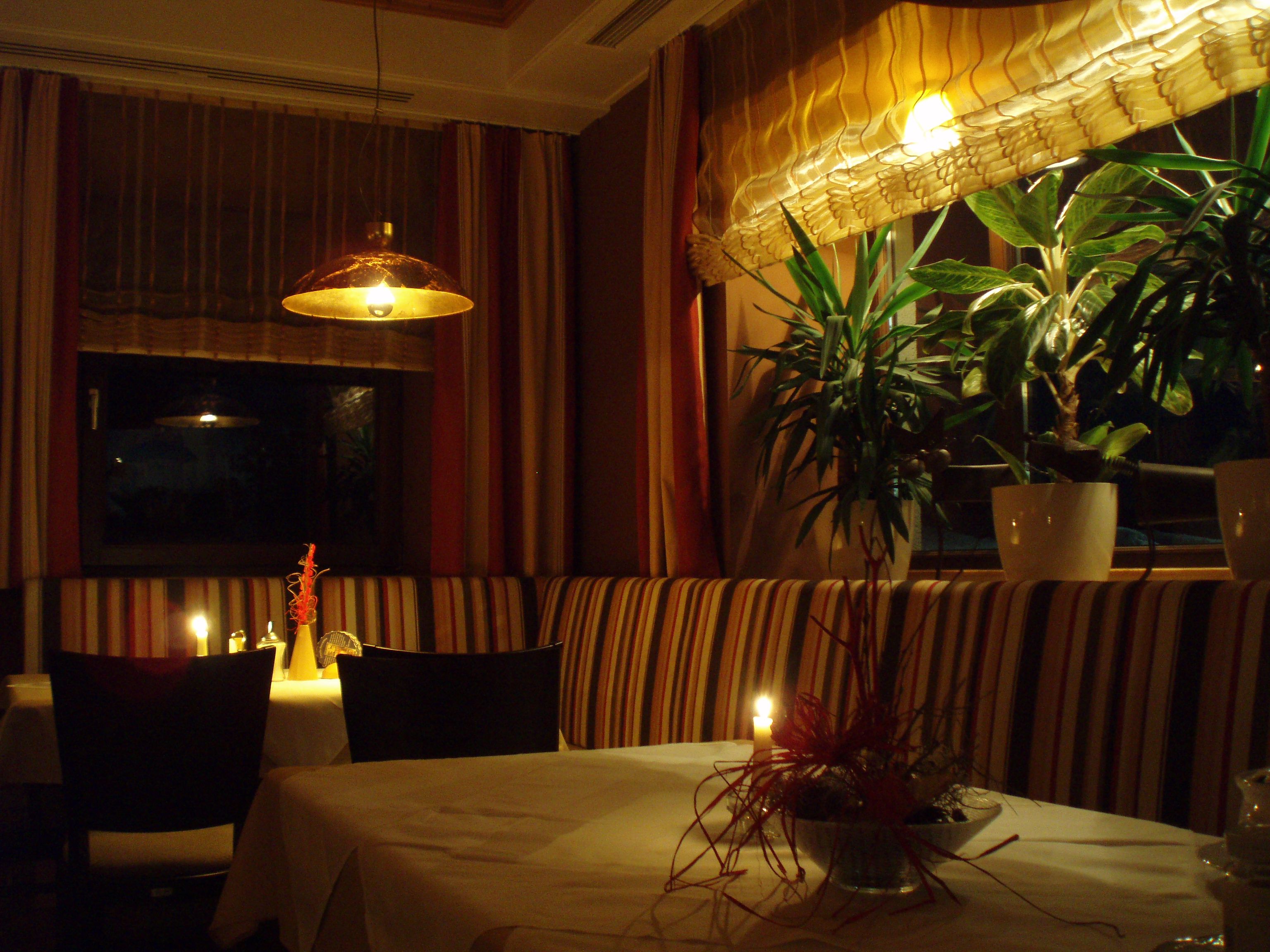 Útulná restaurace se svíčkami a rostlinami.