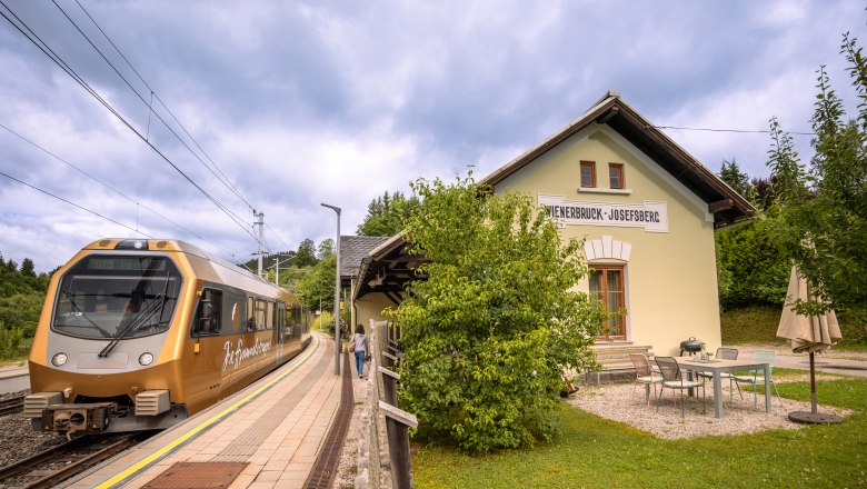 Dovolená v hotelu BAHNhof, © Niederösterreich Werbung / Maximilian Pawlikowsky Na nádraží Wienerbruck-Josefsberg, obklopeném zelení a malým venkovním posezením, zastavuje zlatý vlak.