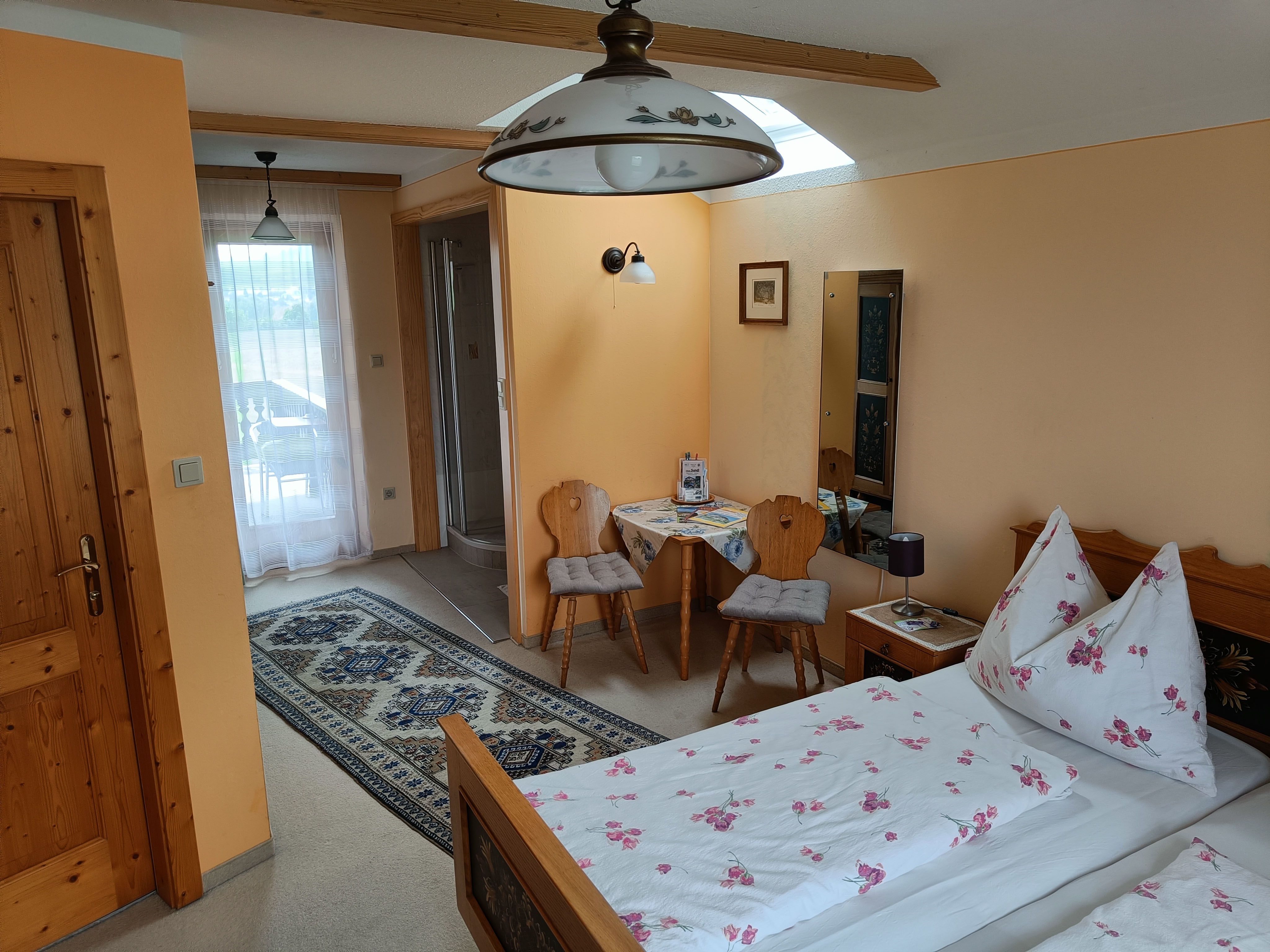 Pokoj s postelí, stolem a 2 židlemi