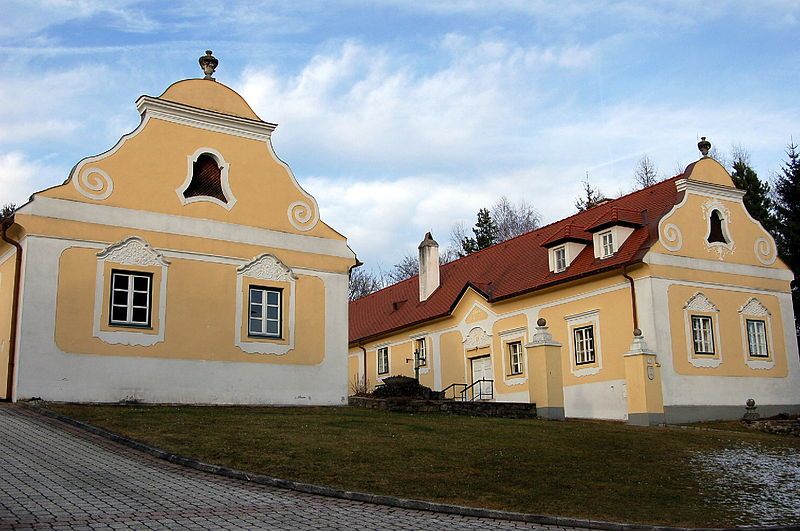 Historická fara v Krumbachu se žlutými fasádami a červenými střechami.