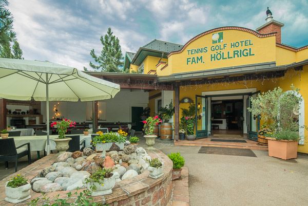 Vstup do tenisového golfového hotelu Höllrigl s terasou a rostlinami.