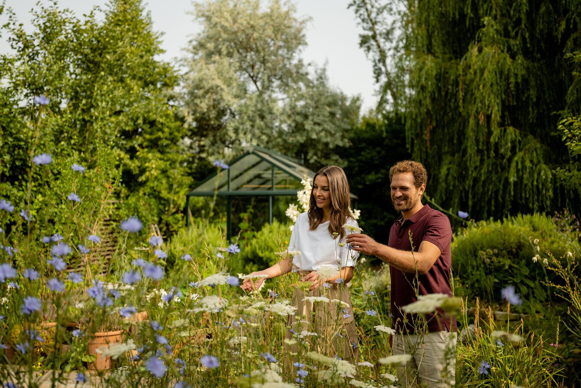 Inmitten eines blühenden Gartens genießen zwei Menschen die Farbenpracht der Natur. Die sanften Blumen und das leise Rascheln der Blätter schaffen eine harmonische Atmosphäre, die zum Verweilen einlädt. Hier wird der Sommer in seiner schönsten Form erlebbar.