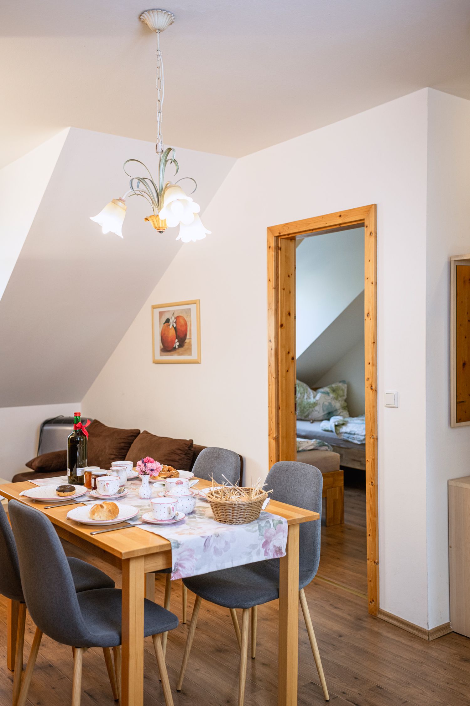 Jídelní kout v rekreačním bytě se stolem a výhledem do ložnice.