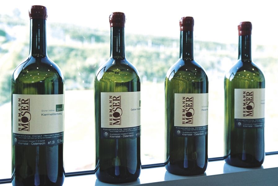 Čtyři láhve vína z vinařství Hermann Moser na parapetu.