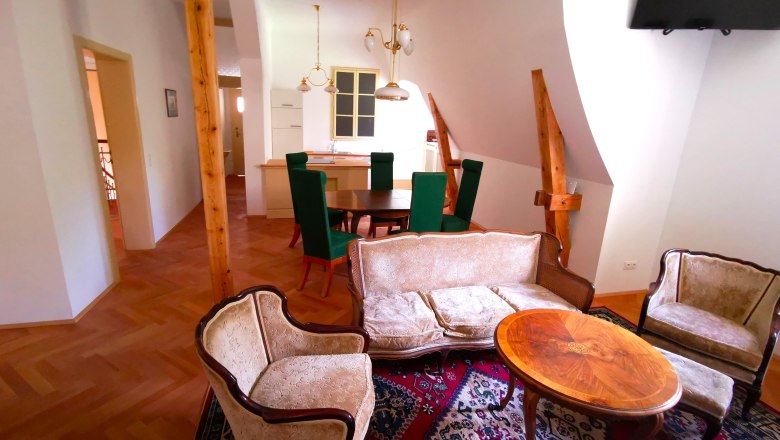 Ob&yacute;vac&iacute; pokoj se starožitn&yacute;m n&aacute;bytkem a dřevěn&yacute;mi tr&aacute;my.