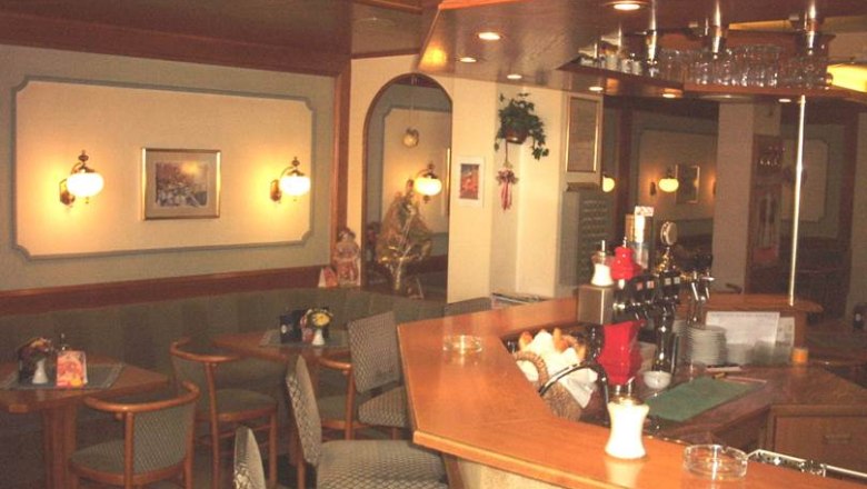 Pohled do interi&eacute;ru &uacute;tuln&eacute; kav&aacute;rny s dřevěn&yacute;mi pulty a posezen&iacute;m.