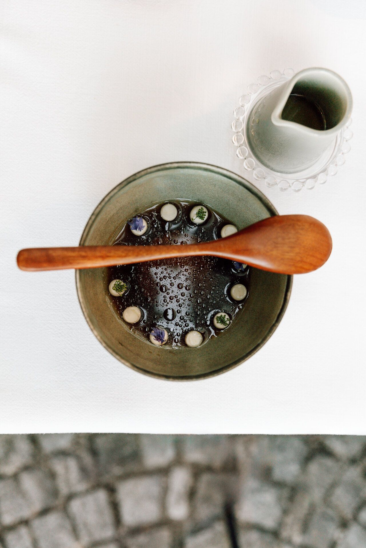 Osoba sedí na stoličce v prostém interiéru a dívá se do kamery.