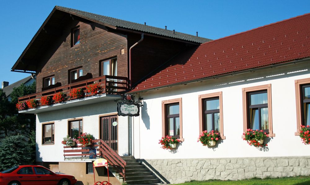 Gasthaus Malzer s květinami vyzdobeným balkonem a okny.