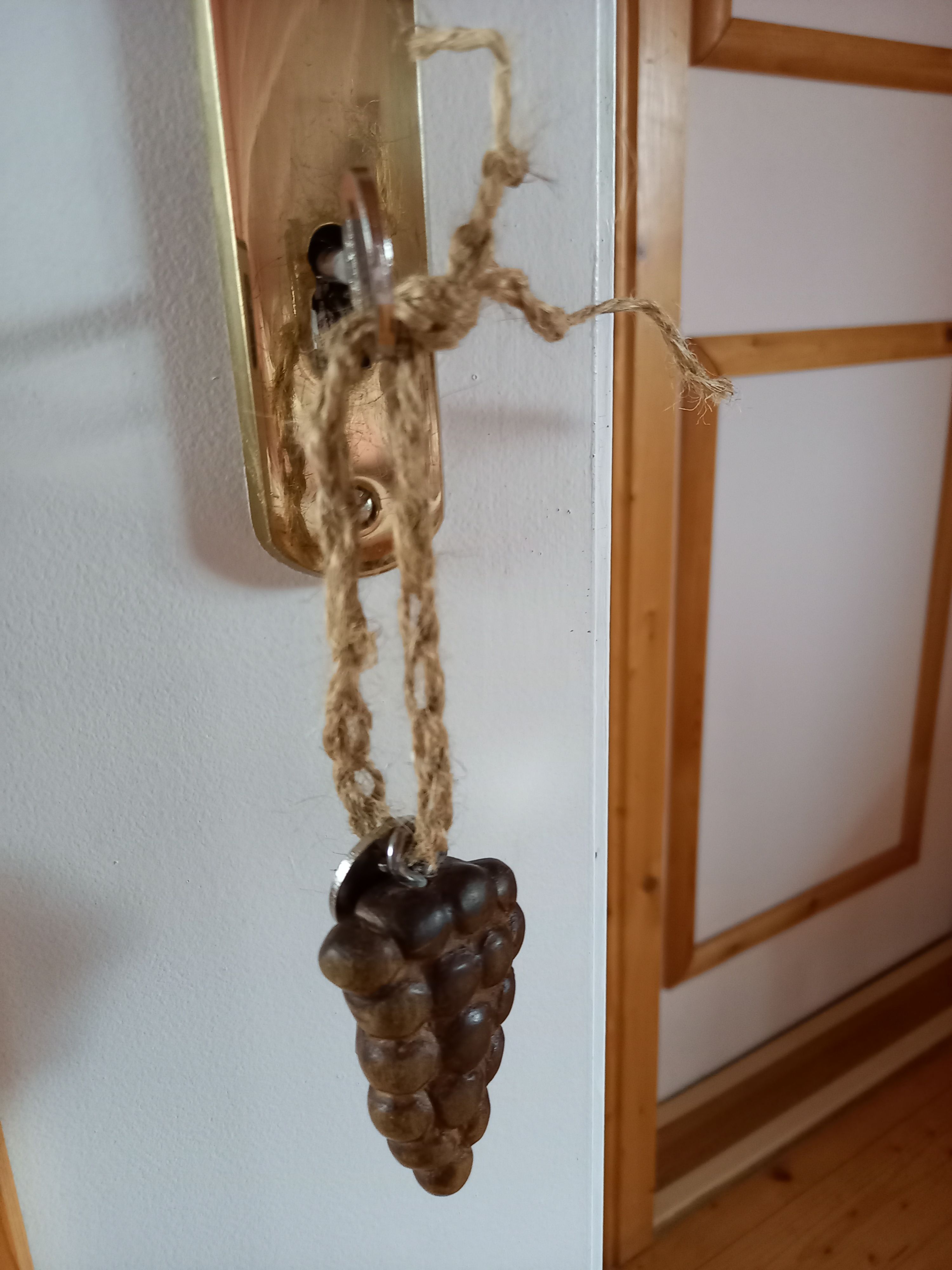 Dveřní klika s dřevěným přívěskem hroznu.