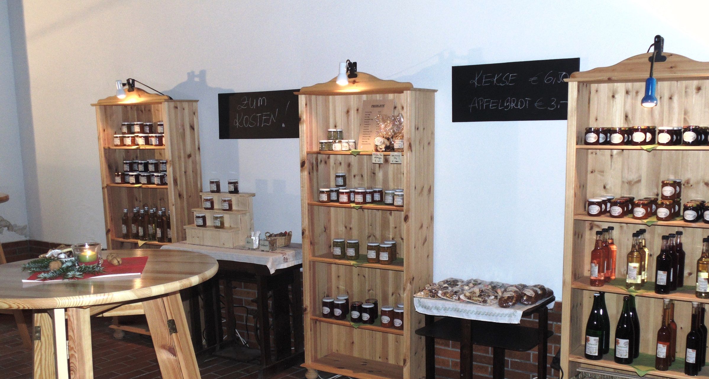 Pohled do interiéru farmářského obchodu s regály plnými džemů, šťáv a sušenek.