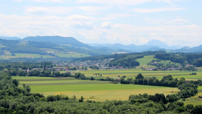 Panorama zelen&eacute; krajiny s kopci, poli a řekou.