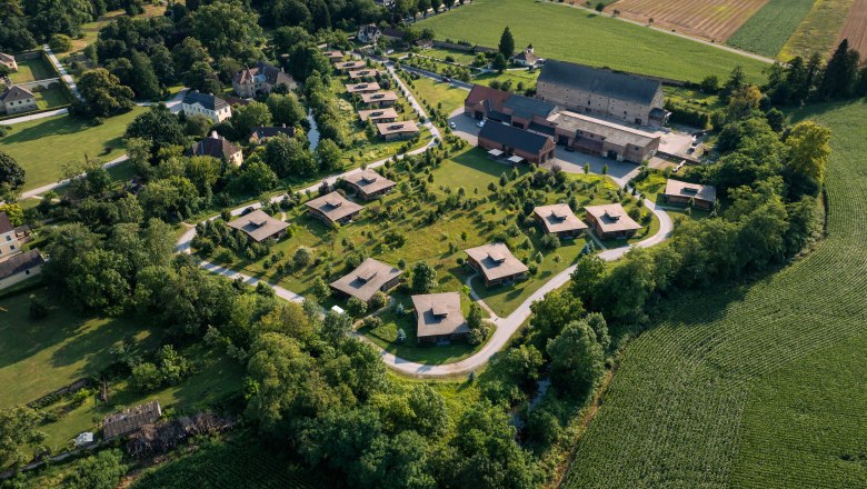 Letecký pohled na chaty Grafenegg obklopené zelenou krajinou a poli.