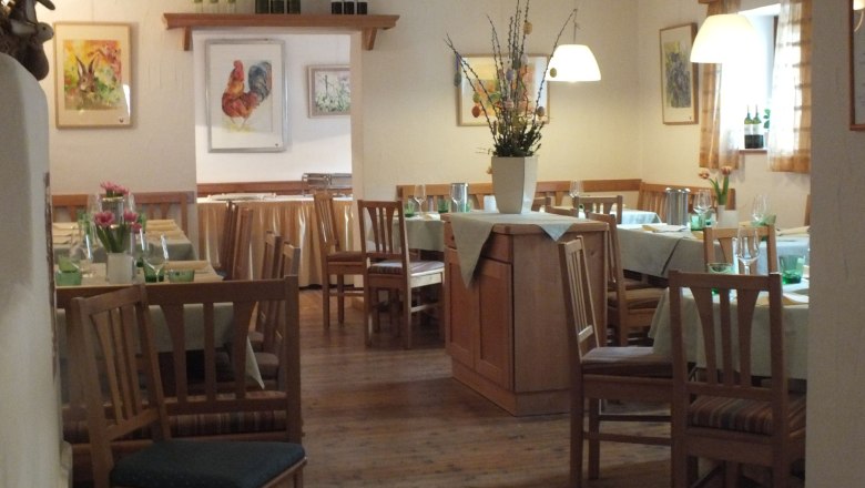 &Uacute;tuln&aacute; restaurace s dřevěn&yacute;m n&aacute;bytkem, prostřen&yacute;mi stoly a v&aacute;zami s květinami. Obrazy zv&iacute;řat na stěn&aacute;ch.