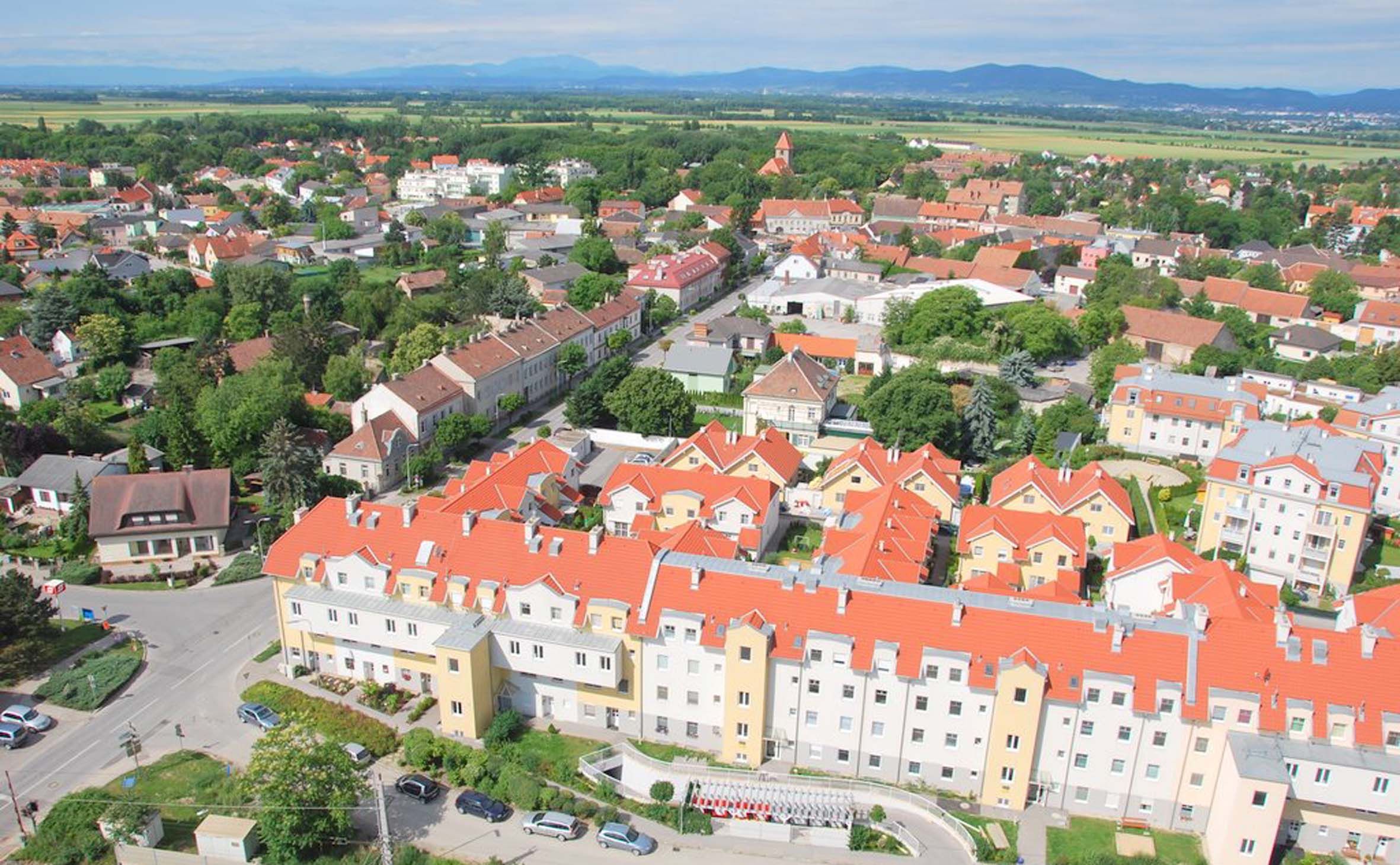 Letecký pohled na Himberg s červenými střechami a zelenou krajinou.