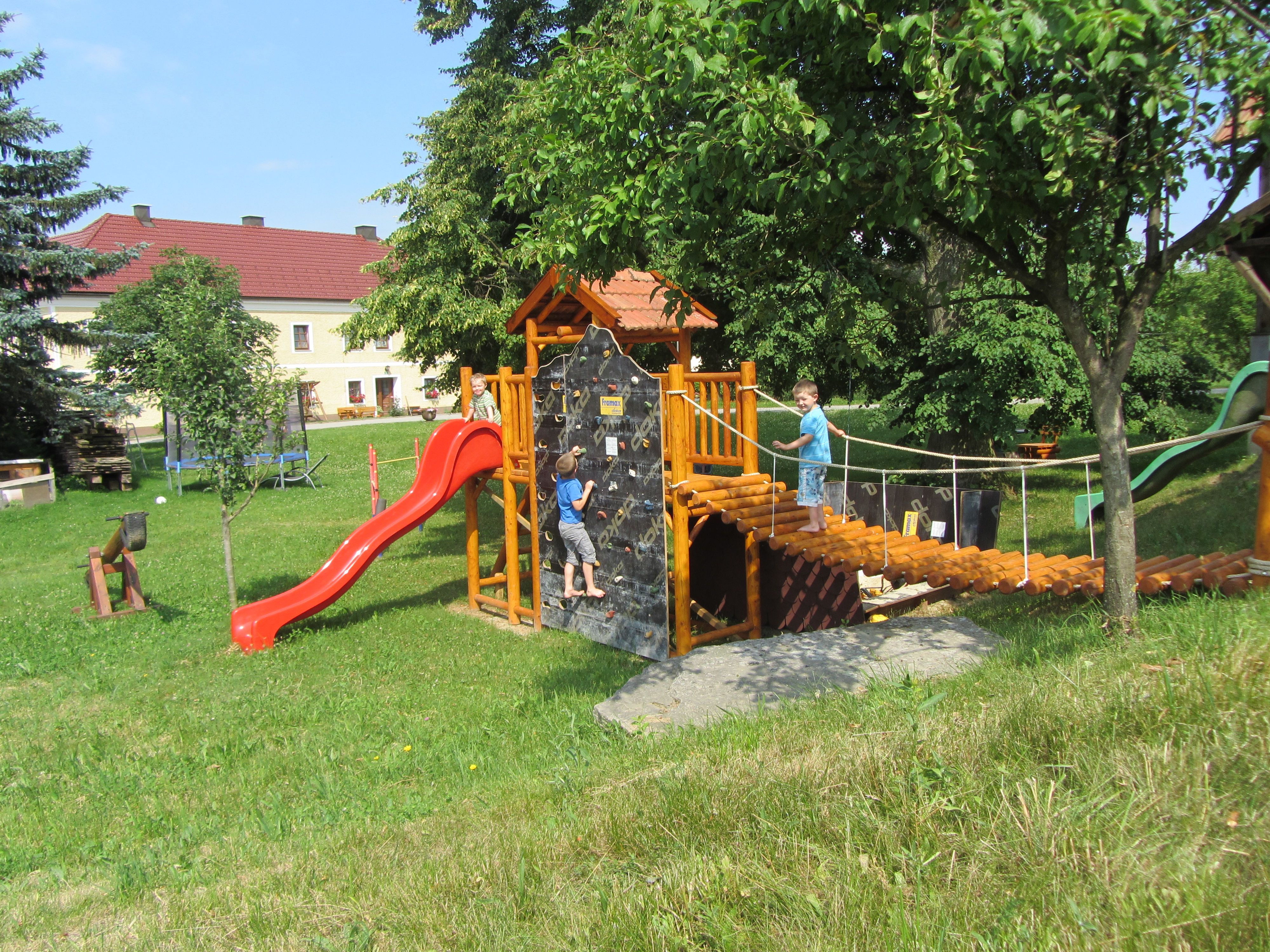Dětské hřiště s prolézačkami, skluzavkou a dvěma hrajícími si dětmi.