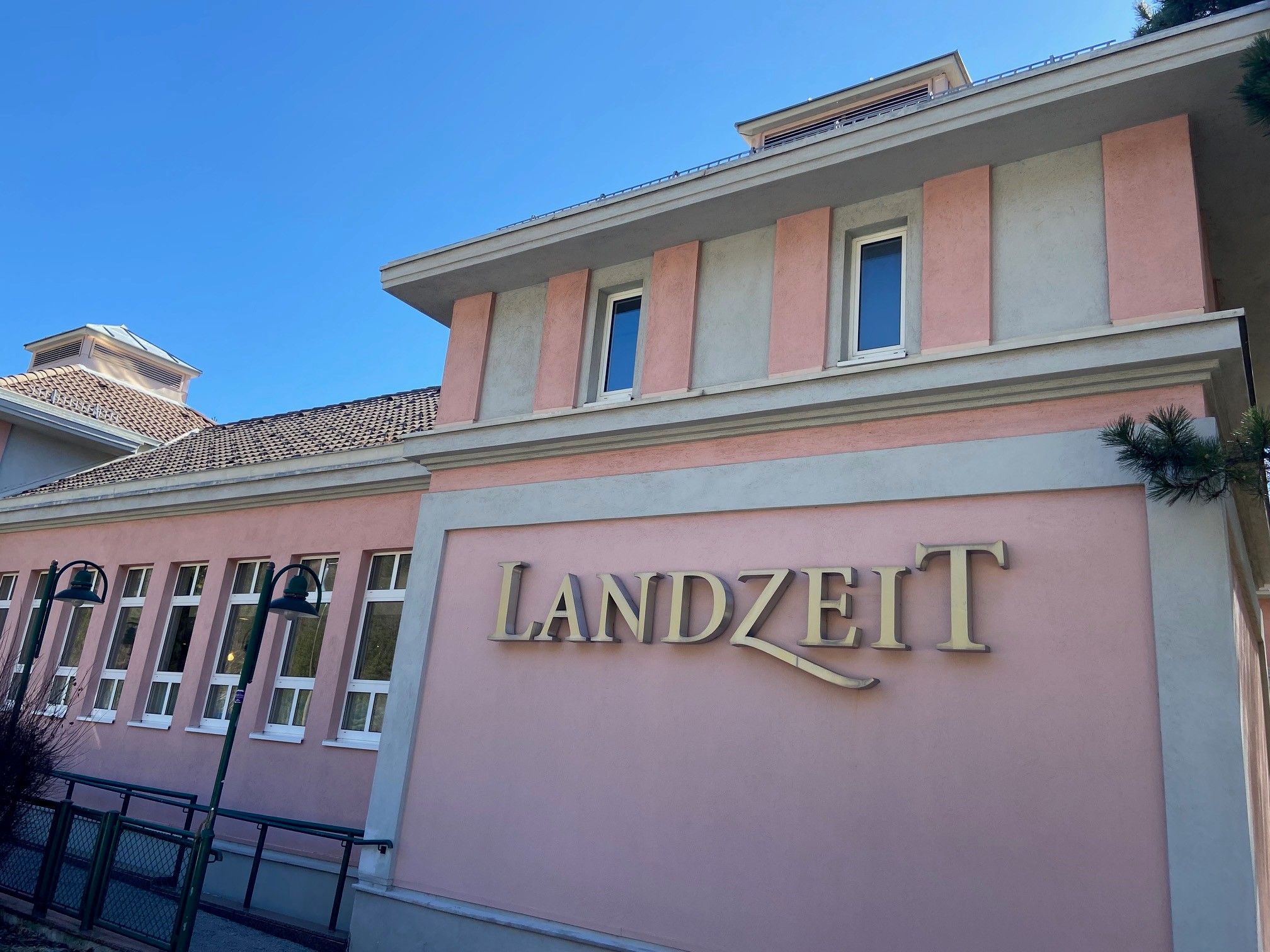 Budova s růžovou fasádou a nápisem "Landzeit".