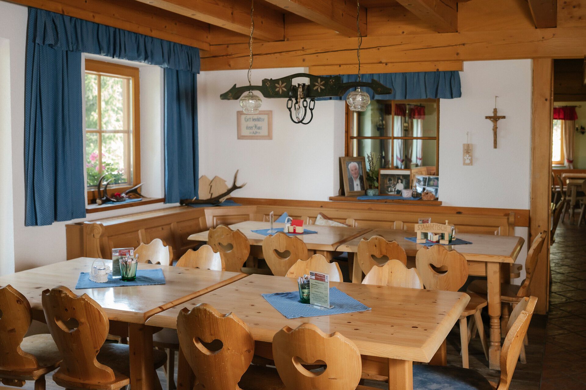 Jídelna s židlemi ve tvaru srdce a modrými závěsy v horské chatě Hengsthütte na Schneebergu