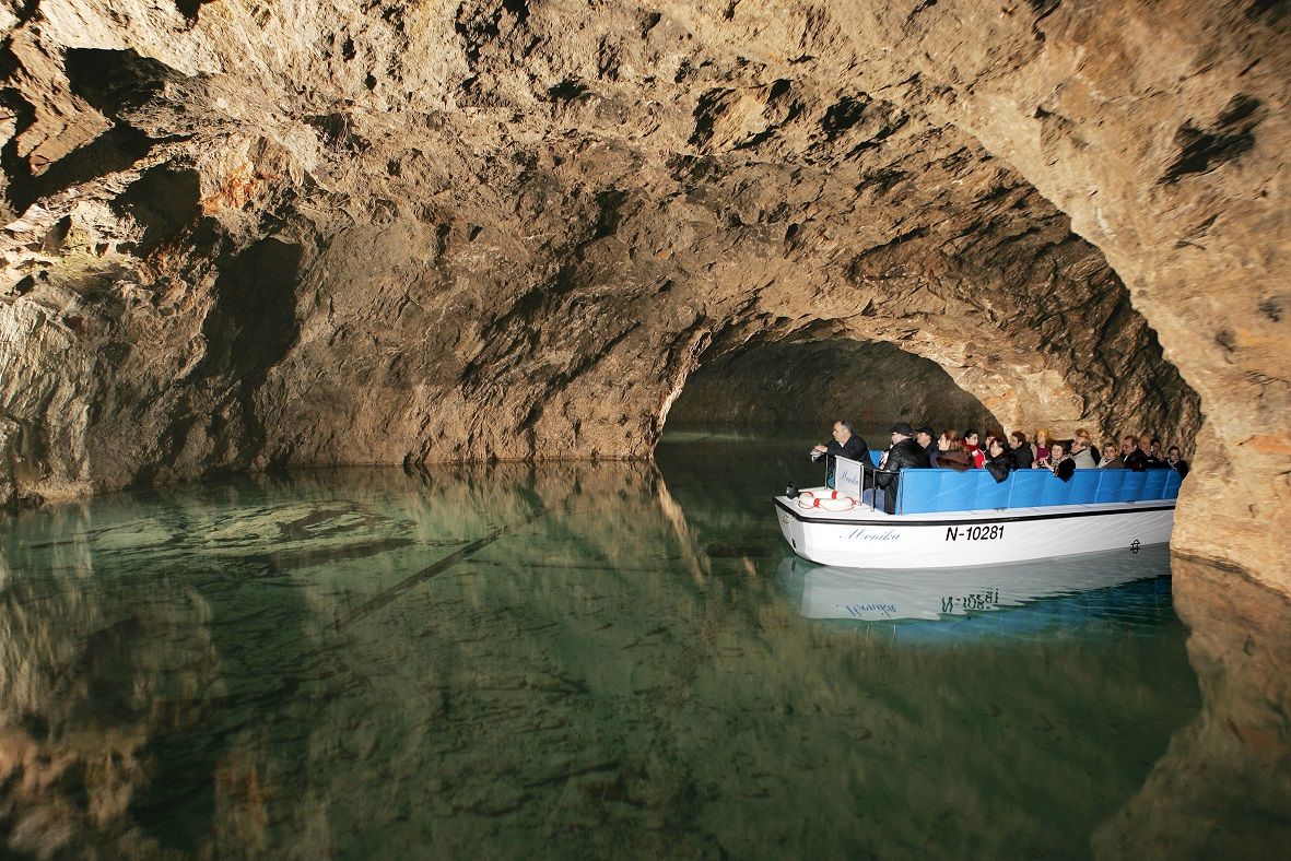 Výlet lodí do podzemní jeskyně s turisty na malé lodi.